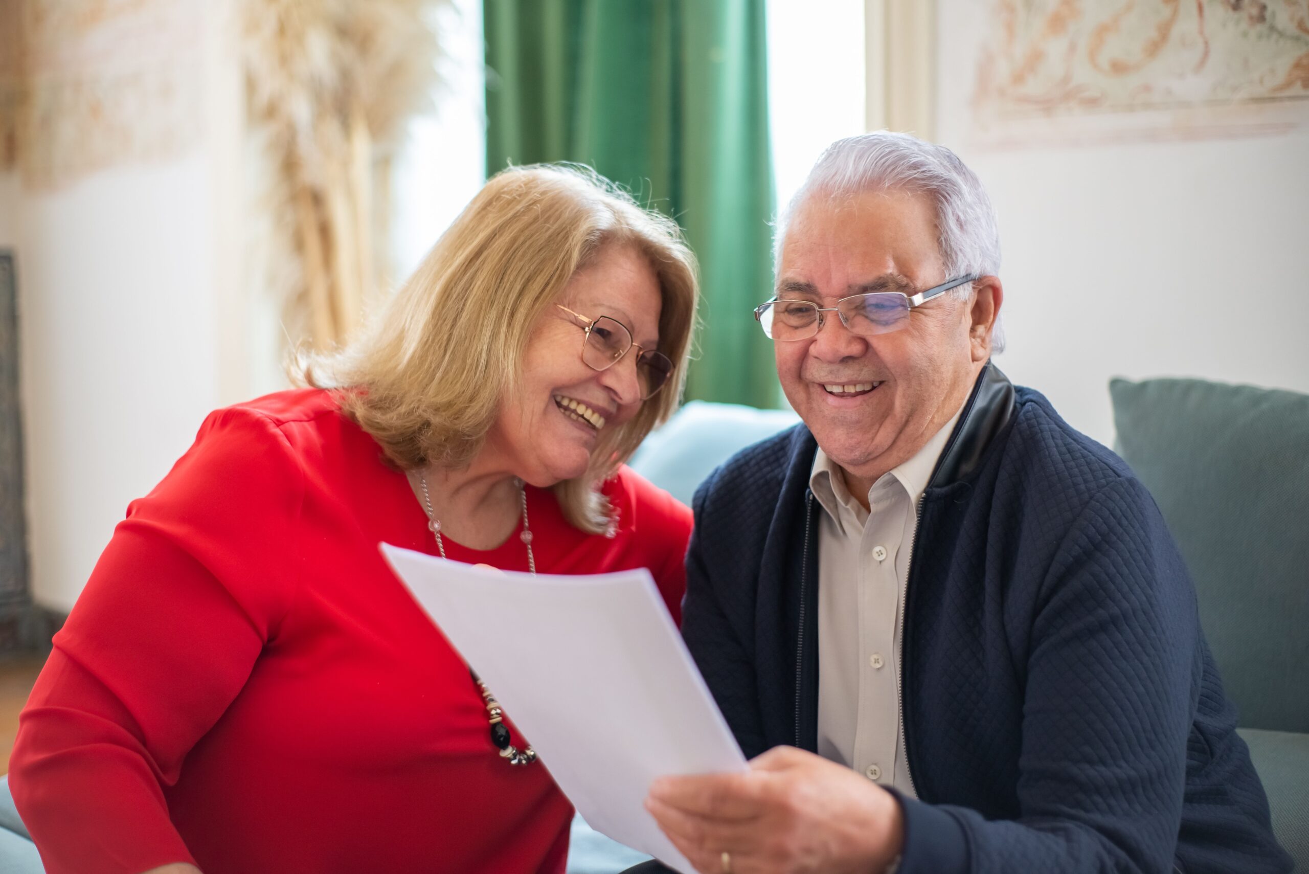 A relaxed older couple reviewing their home-sale options together at home